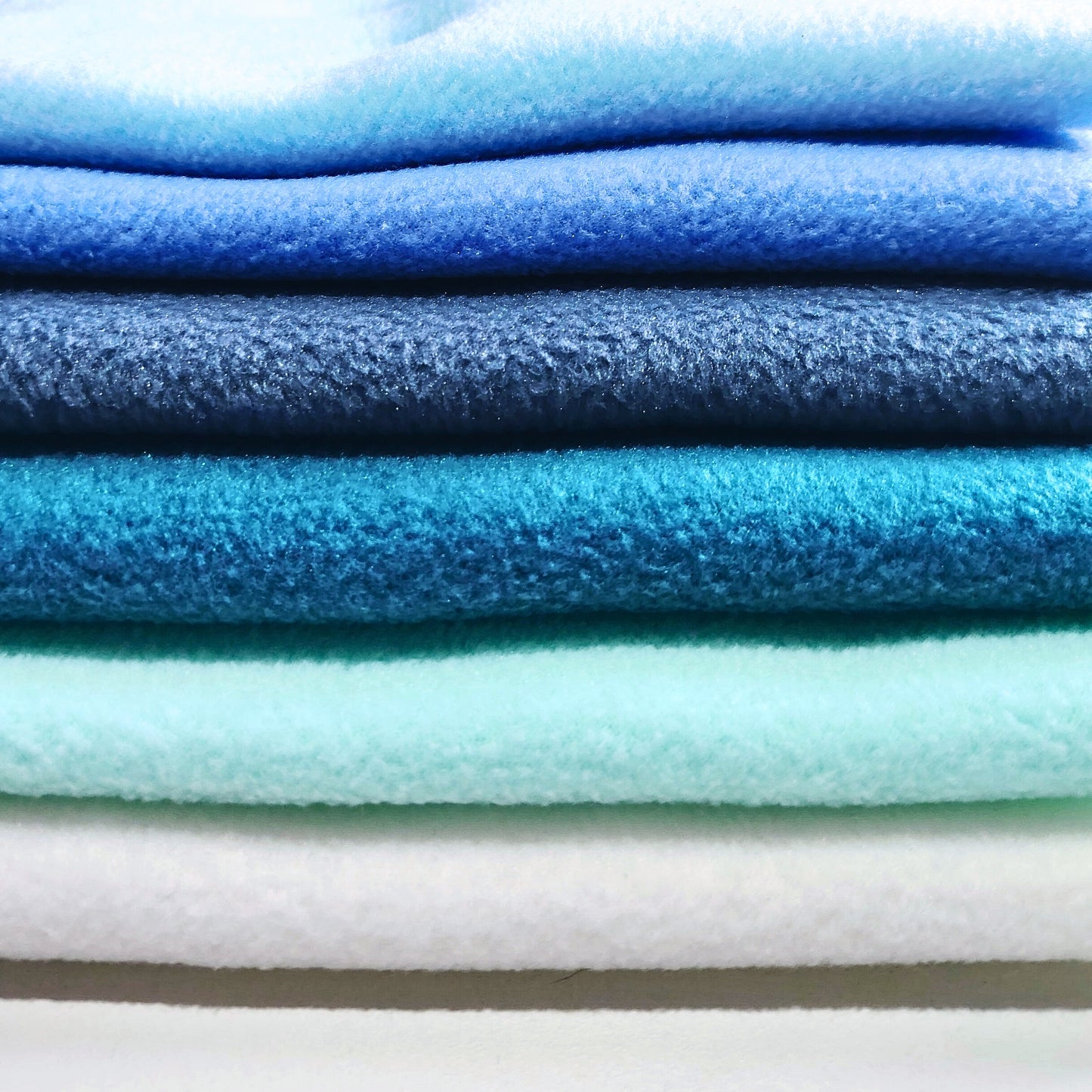 Stacked fleece fabric in cool tones used in Nova Zeal dog enrichment toys.