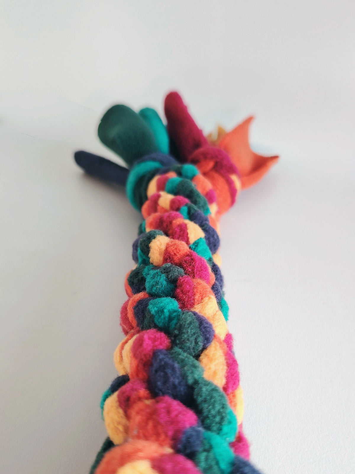 Soft fleece braided tug toy in warm tones with shallow depth of field.