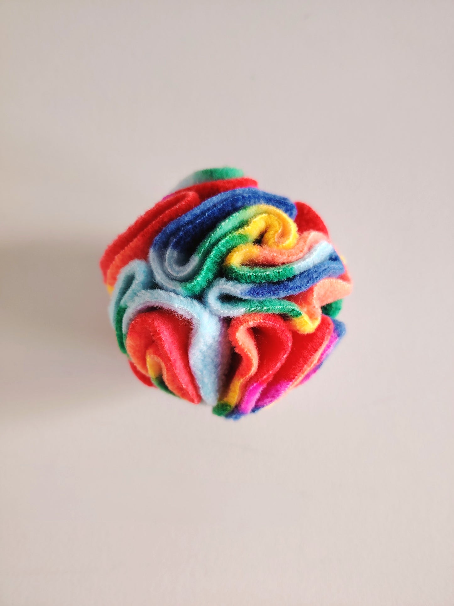 Rainbow Pocket Snuffle Ball dog enrichment toy on a light background.