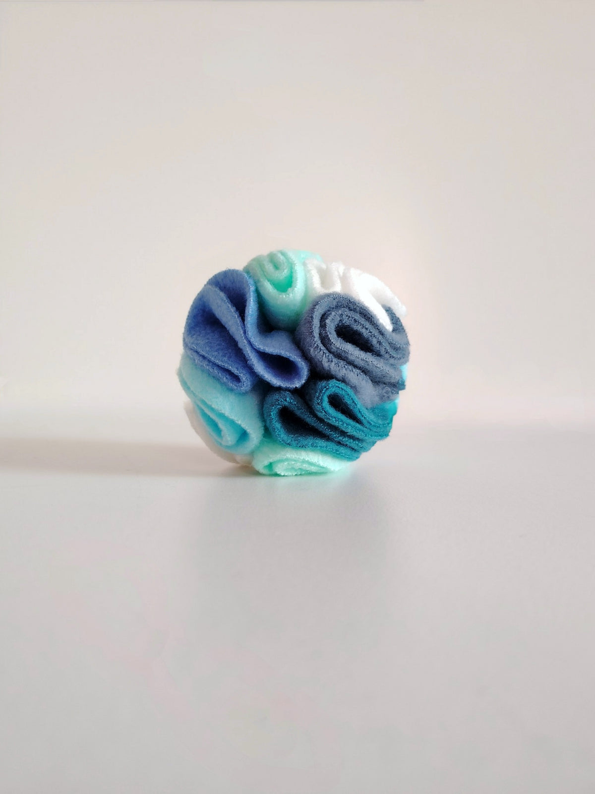 Pocket snuffle ball in cool blue and green fleece for dog enrichment.