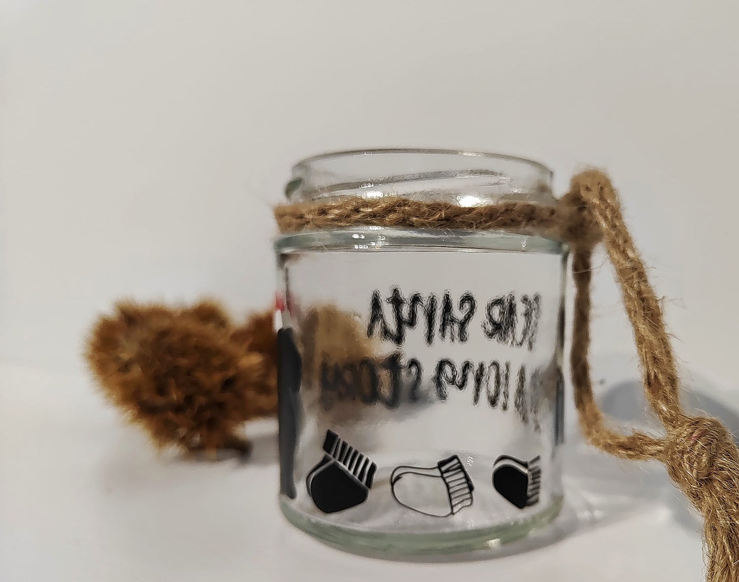 Clear Glass jar with text on the front of the jar and a row of socks on the back