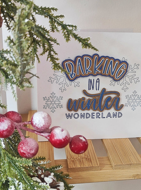 Decorative Christmas card with 'Barking in a Winter Wonderland' text, surrounded by Christmas decorations.