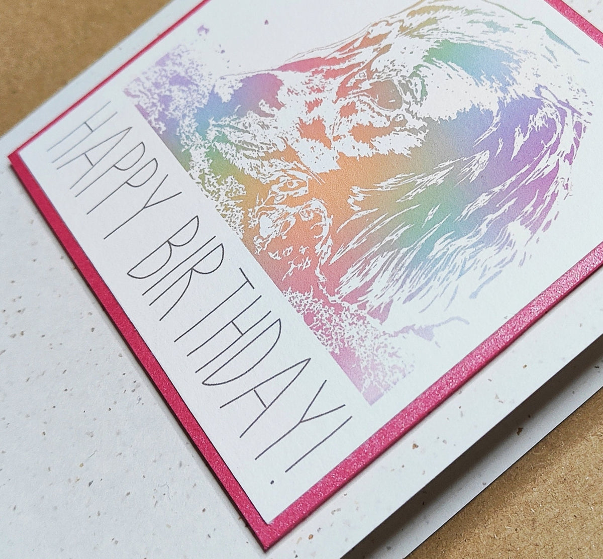Close-up detail of a colourful Cocker Spaniel Happy Birthday card on recycled card.