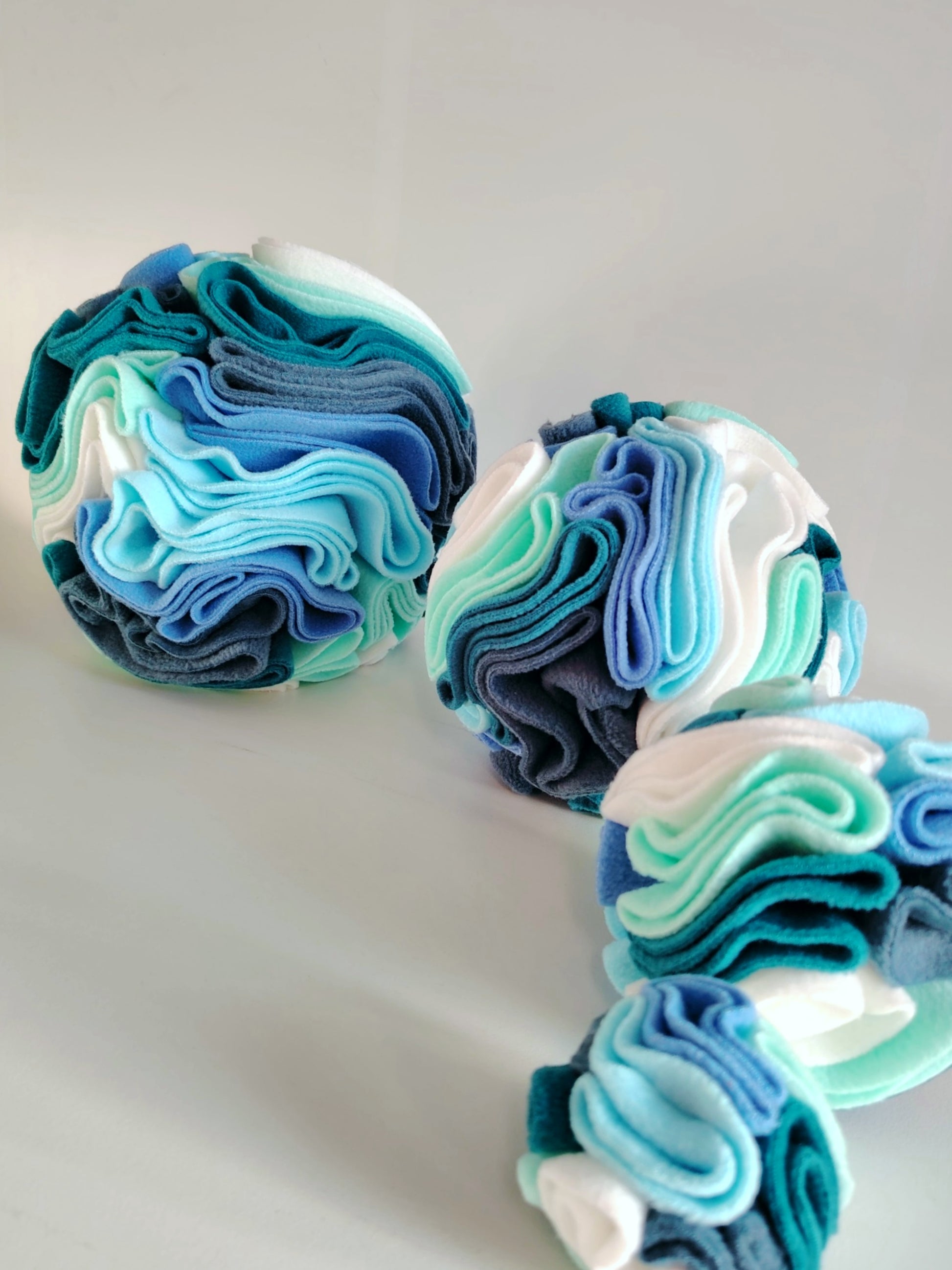 Snuffle balls in cool tones grouped together for dog enrichment and play.