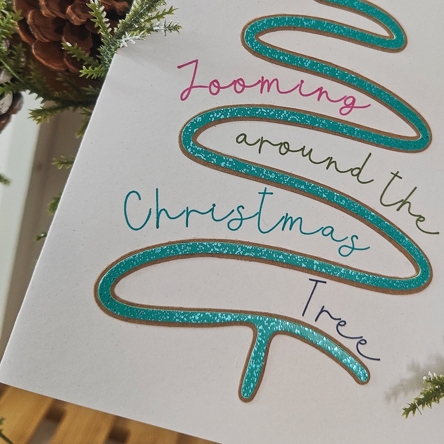 Close-up of a dog themed Christmas Card with decorative text 'Zooming around the Christmas Tree' on a white background