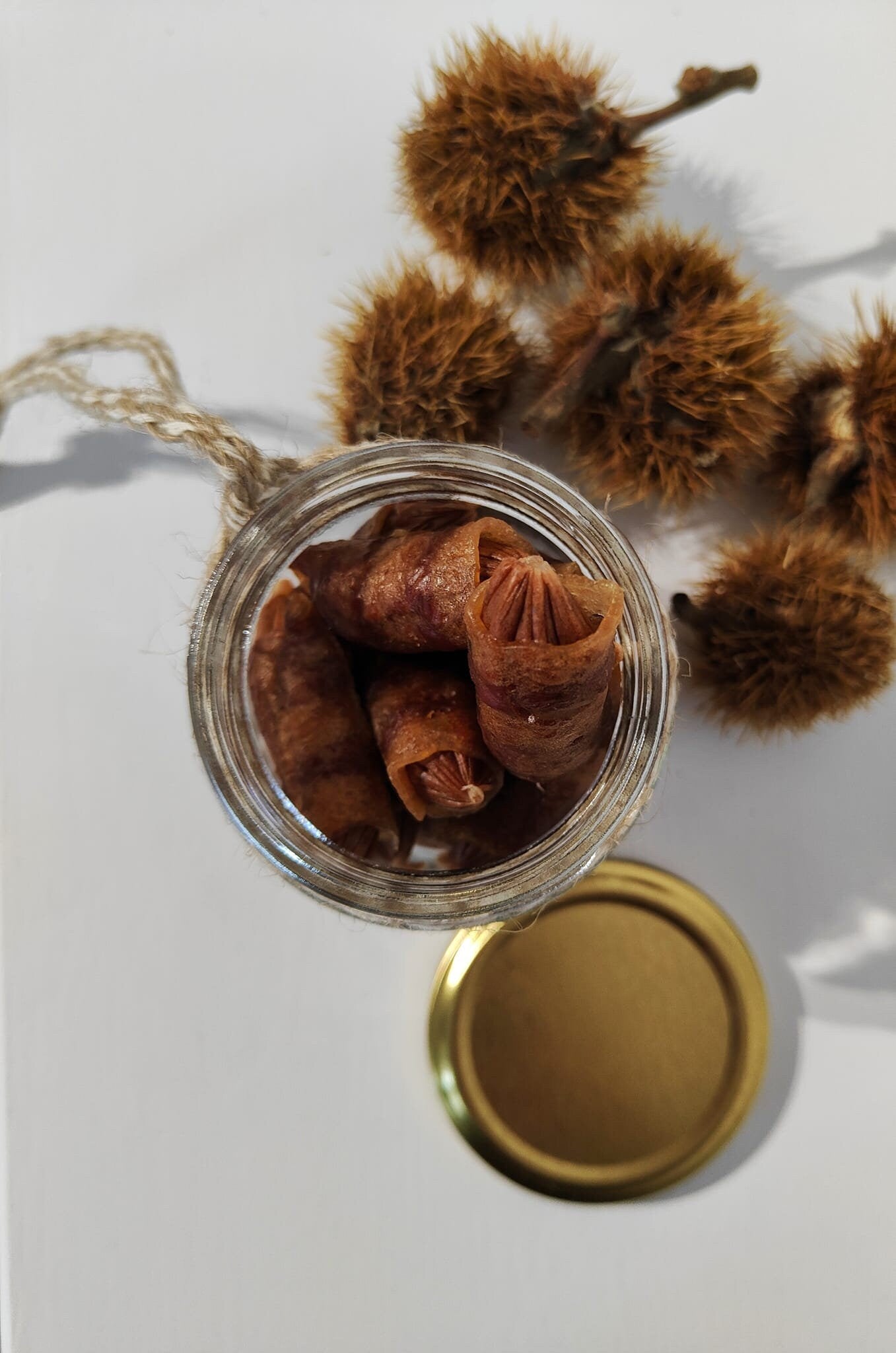 Glass jar filled with dog treats - not included - on a white background