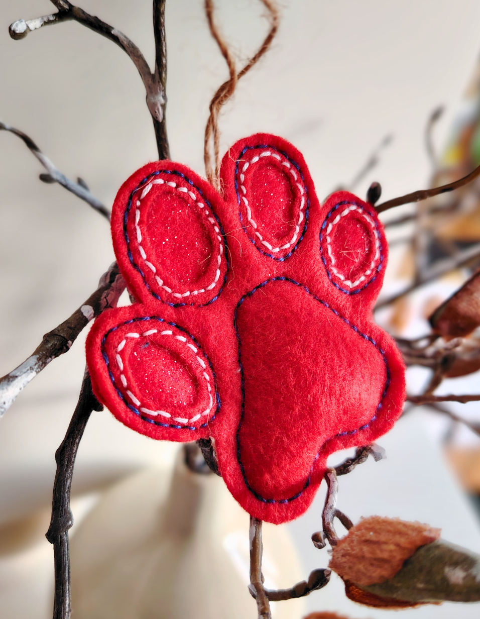 Red felt paw print ornament on a branch