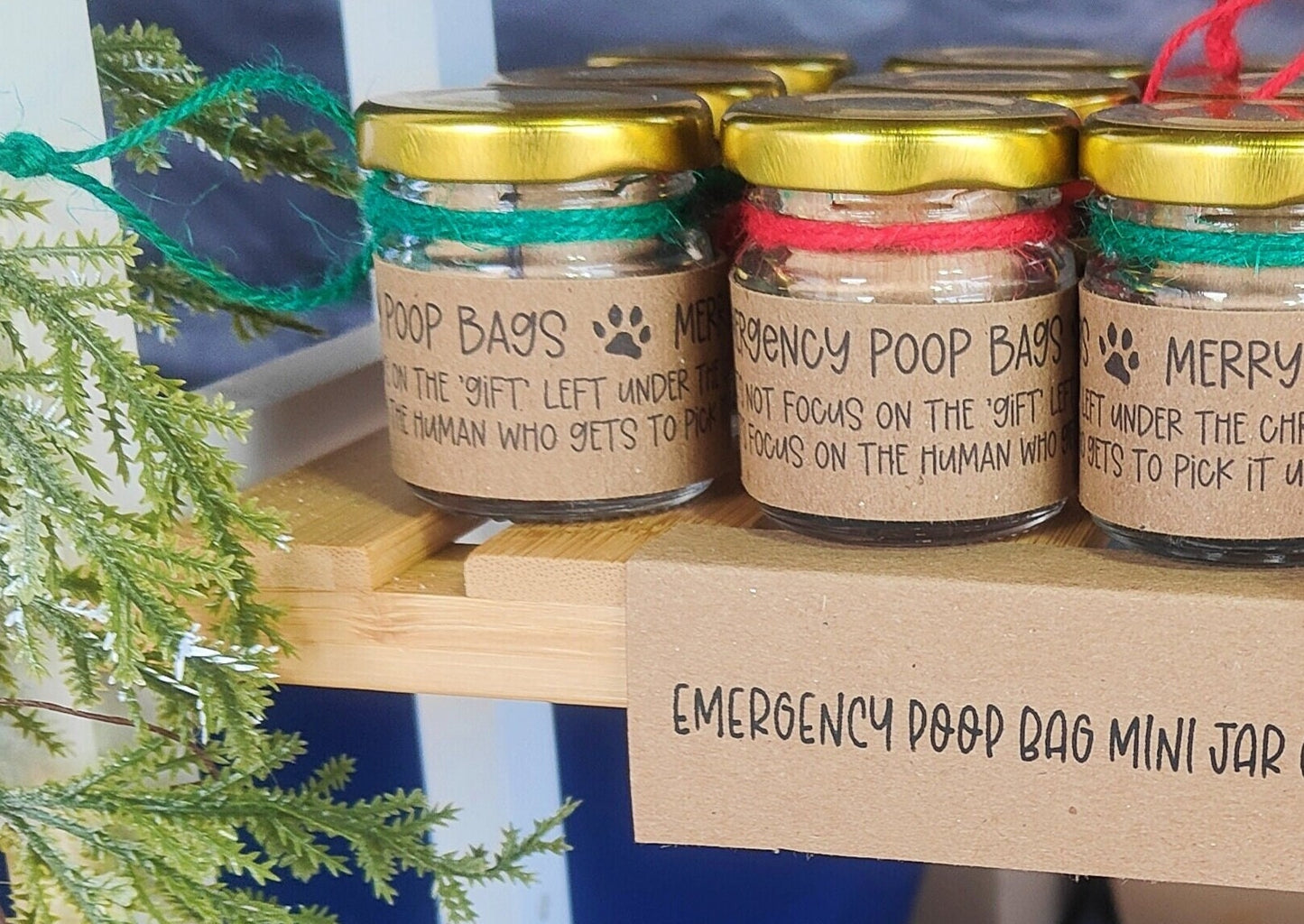 A display shelf of vibrant red and emerald green small jar stocking fillers. 