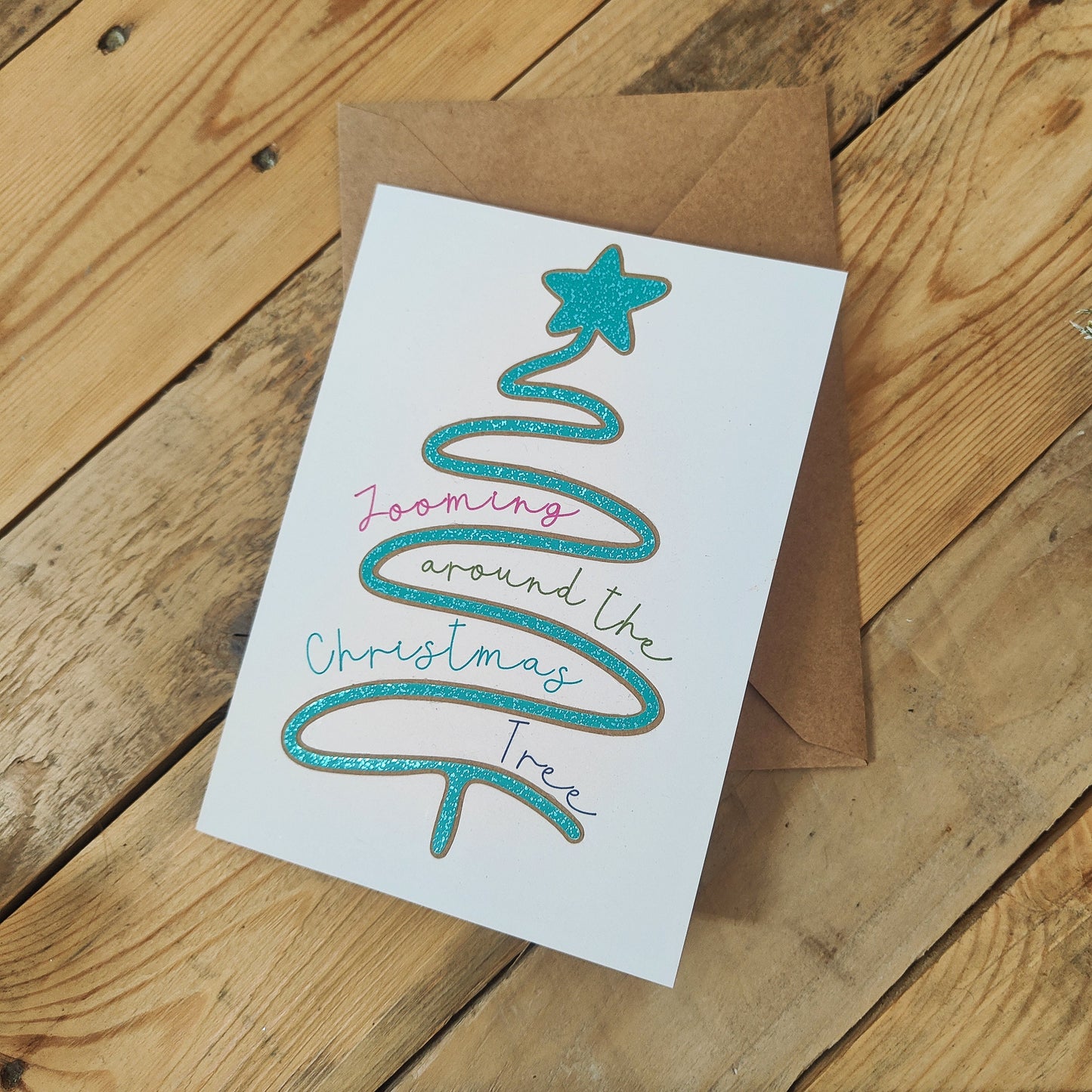 Christmas card with a tree design on a wooden surface