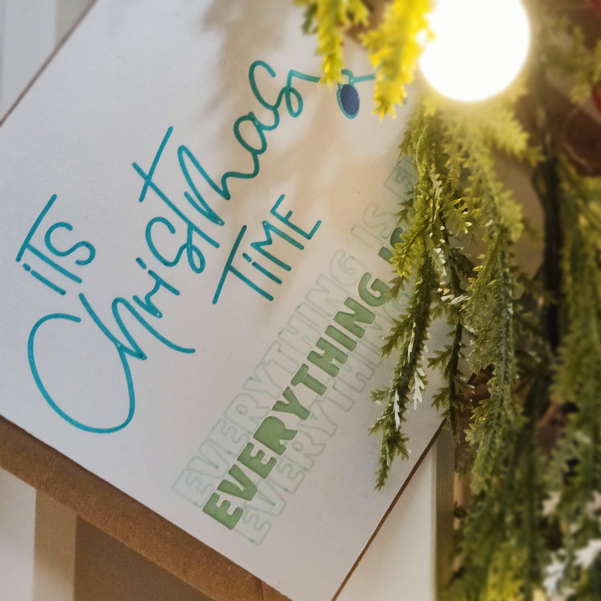 Close-up of the greeting card showing the cut out wording in more detail, 'EVERYTHING IS FINE' text, and festive greenery