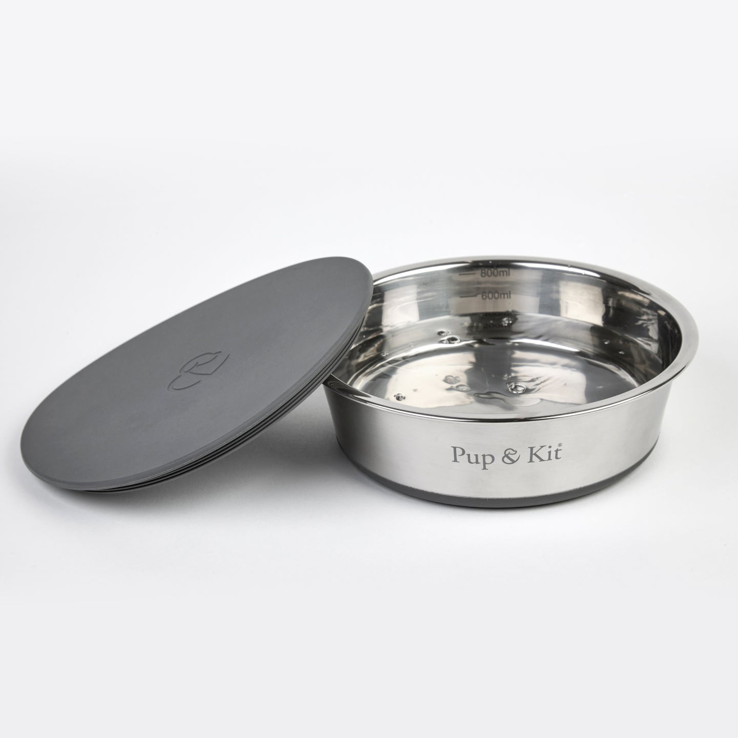 Pup & Kit Lid-it stainless steel pet bowl filled with water, shown with grey stay-fresh lid beside it and measurement markings inside the bowl.
