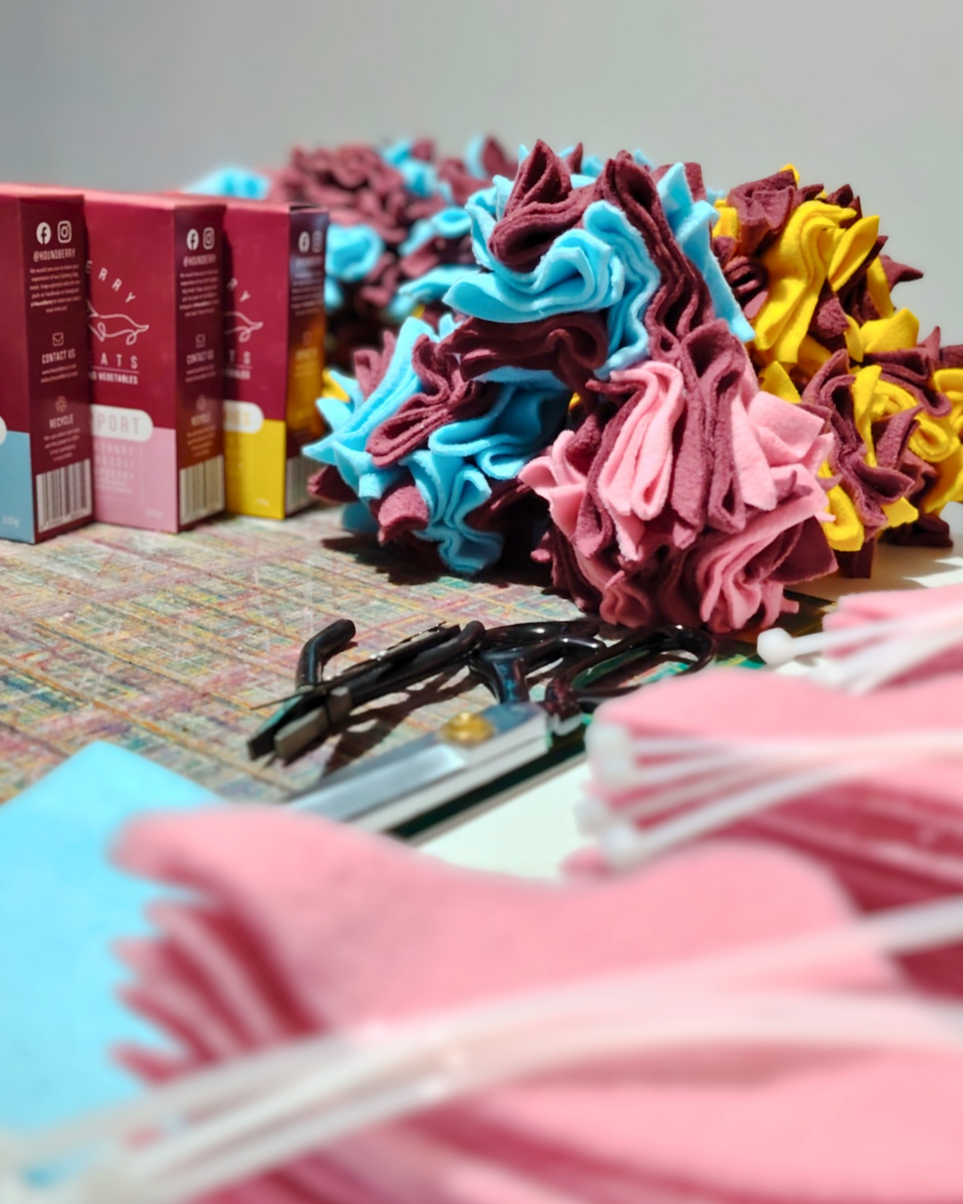 Colourful dog toys being made on a table with a neutral background