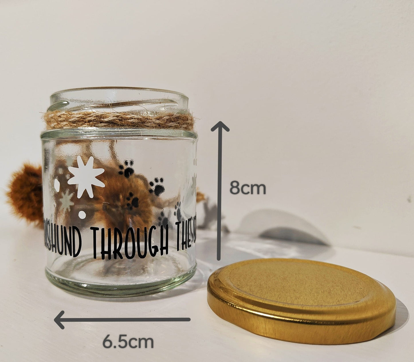 Glass jar with a gold lid and shows measurements (width 6.5cm x height 8cm) on a white background.