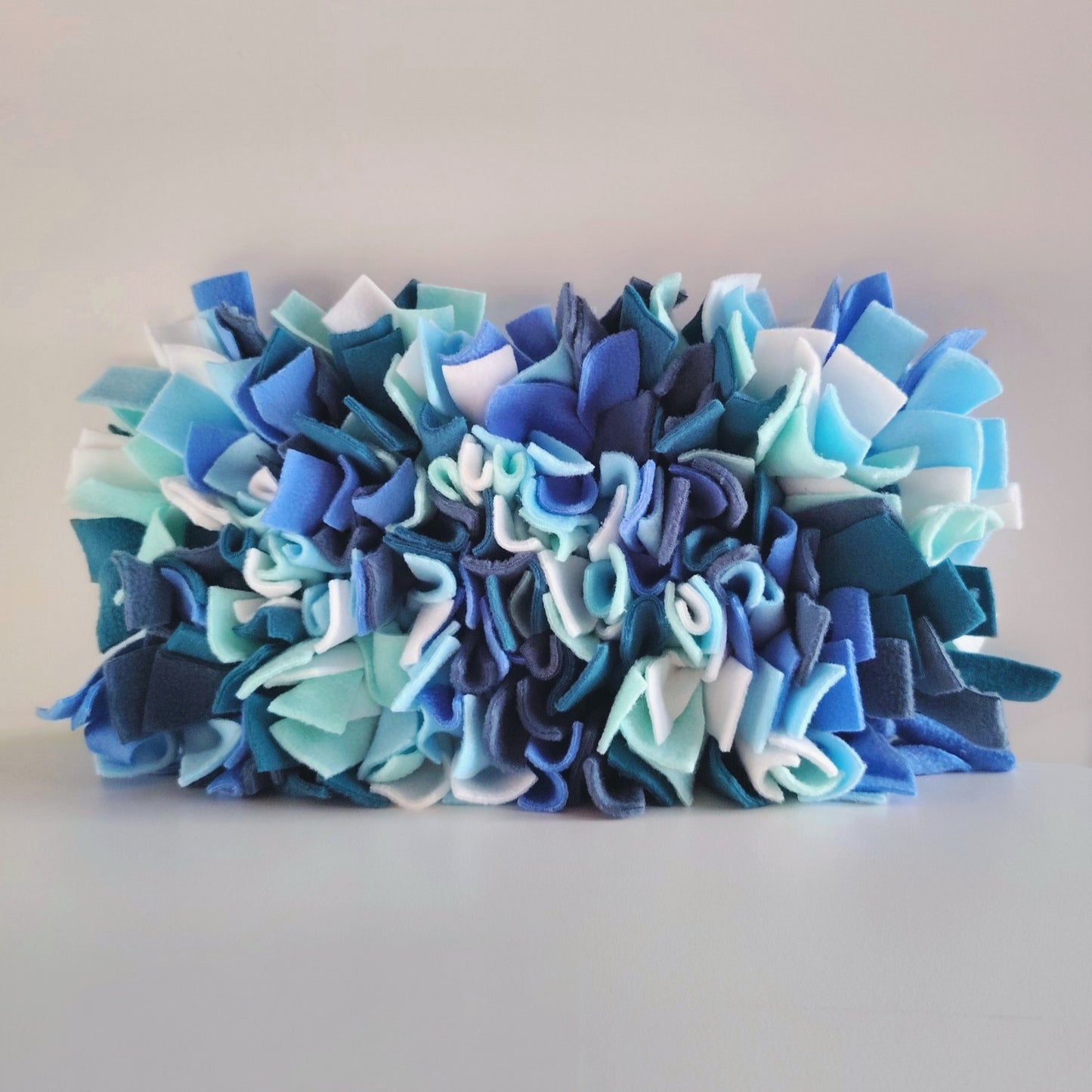 Side view of cool-toned snuffle mat showing layered fleece texture.
