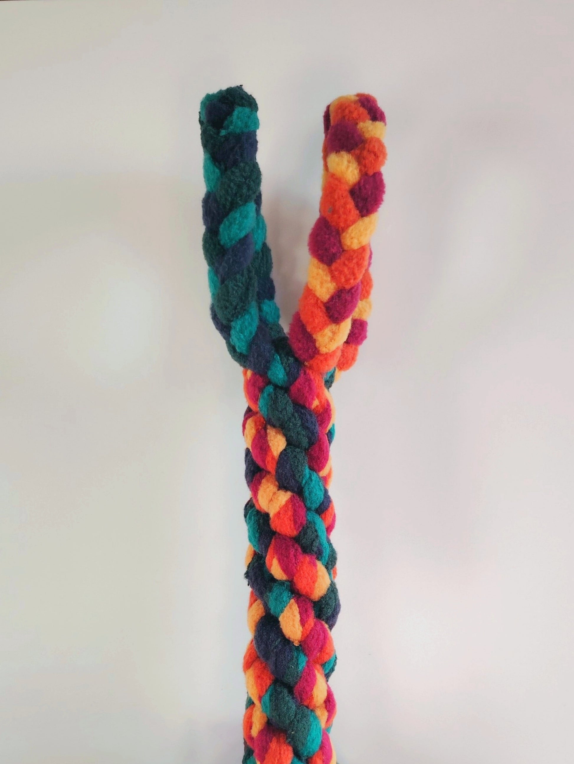 Braided fleece dog tug toy showing strong woven design in warm autumn colours.