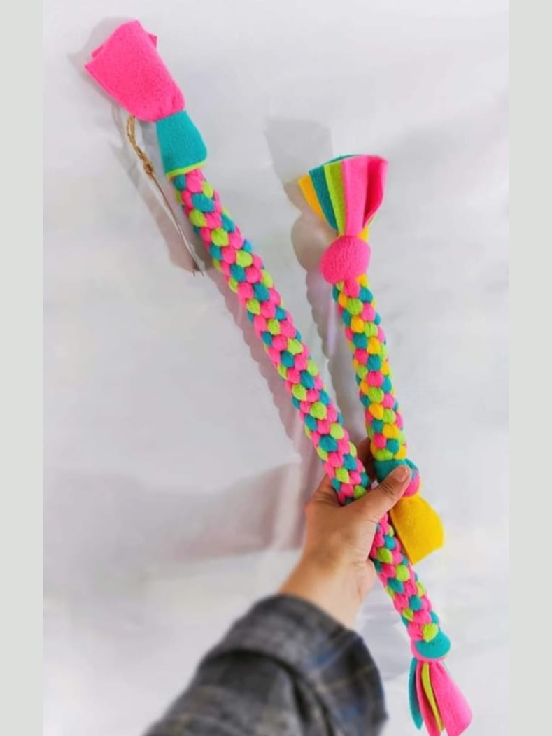 An arm holding up a long and a short Chonk Tug toy side by side, clearly showing the size difference between the two options.