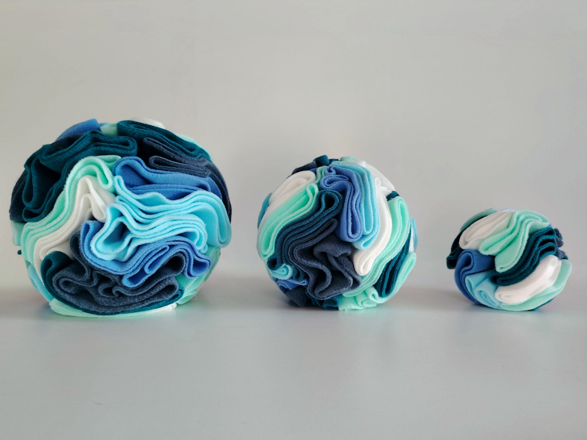 Small medium and large snuffle balls shown side by side for size comparison.
