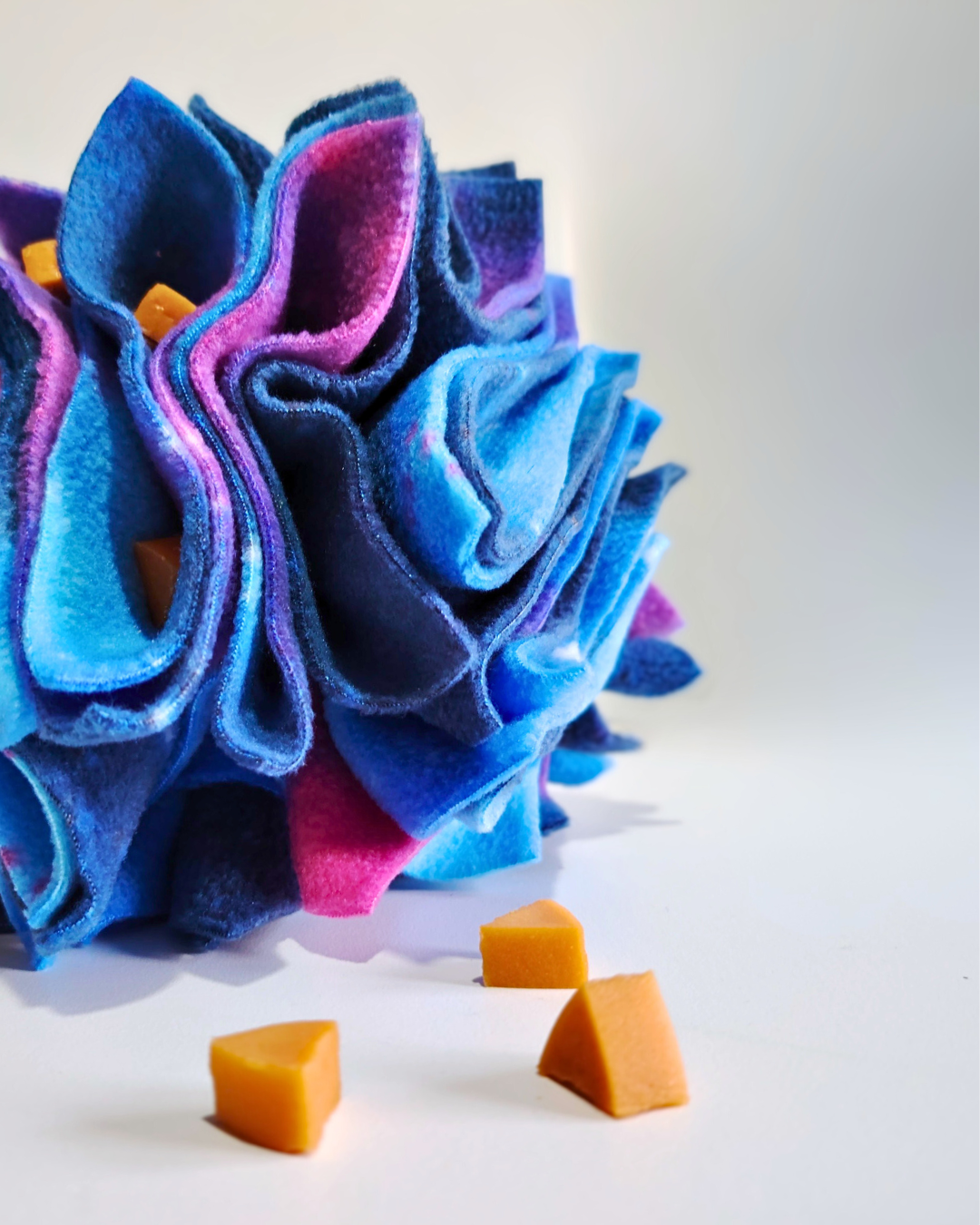 Colourful fleece - Star Scruffle Ball with treats hidden in the ball on a white background