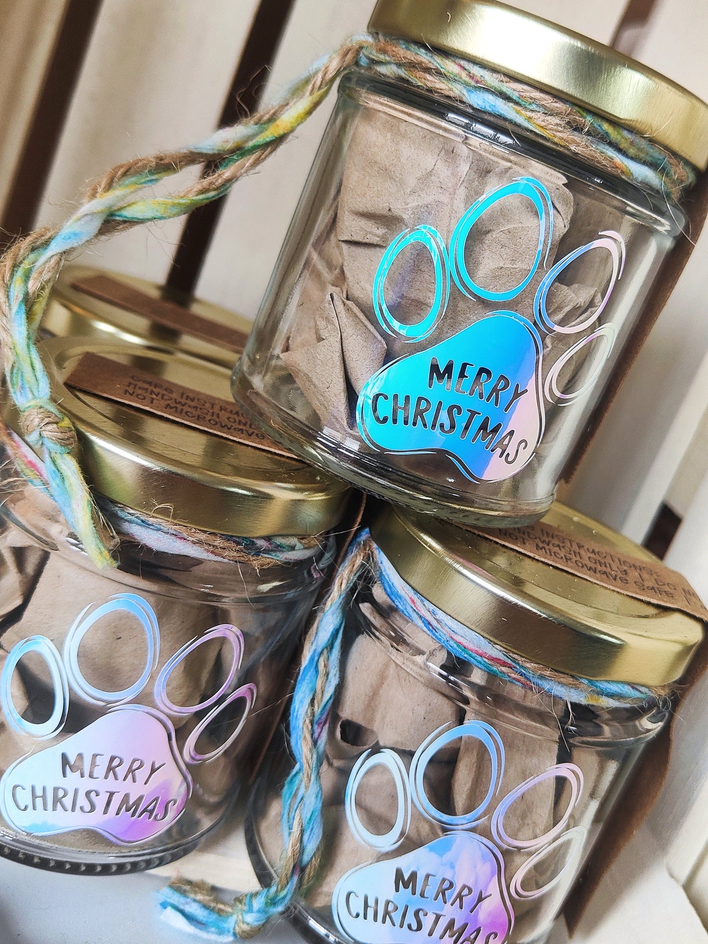 Three glass jars with gold lids and 'Merry Christmas' text on a white background