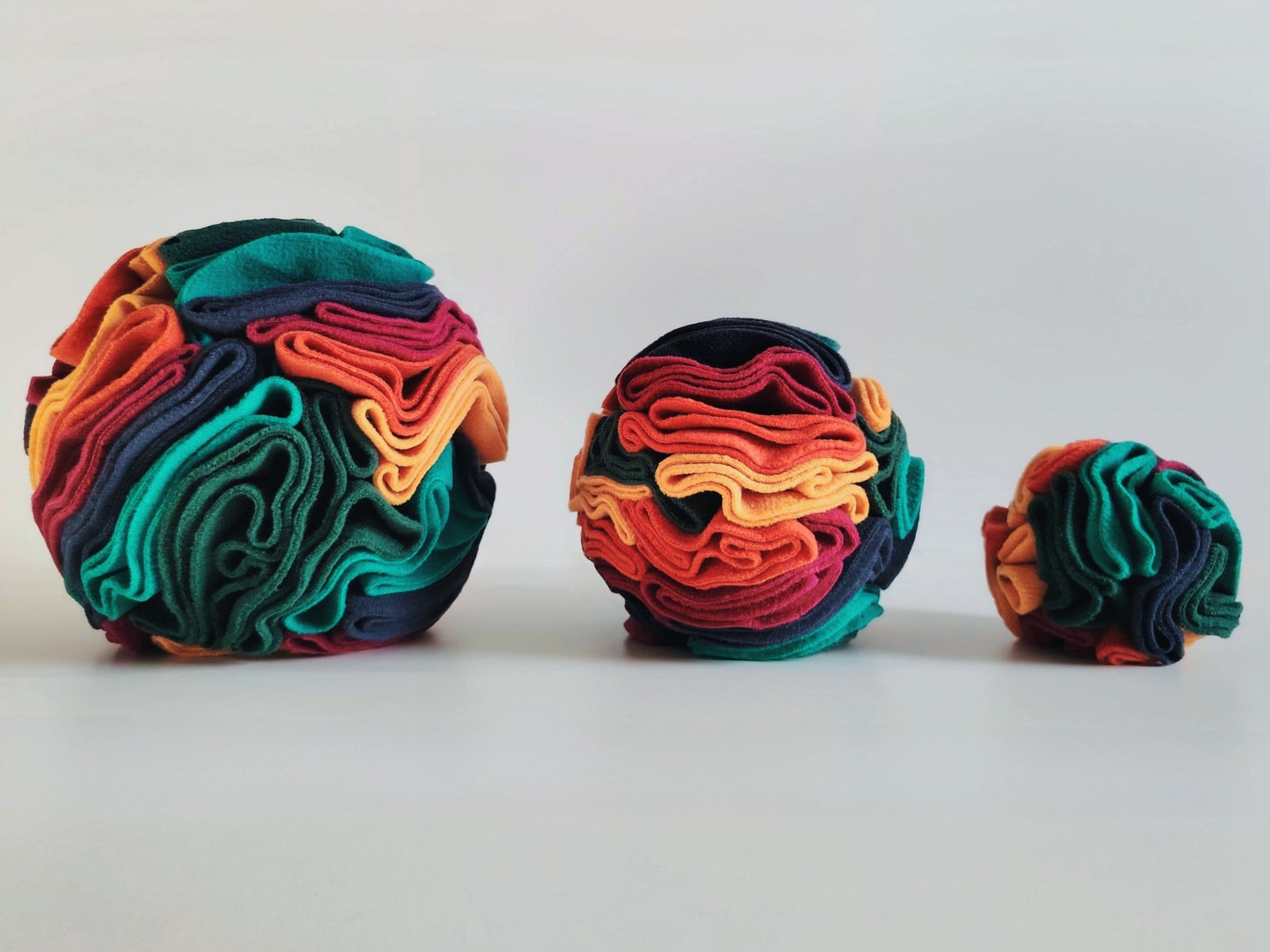 Warm colour snuffle balls in small medium large size comparison.