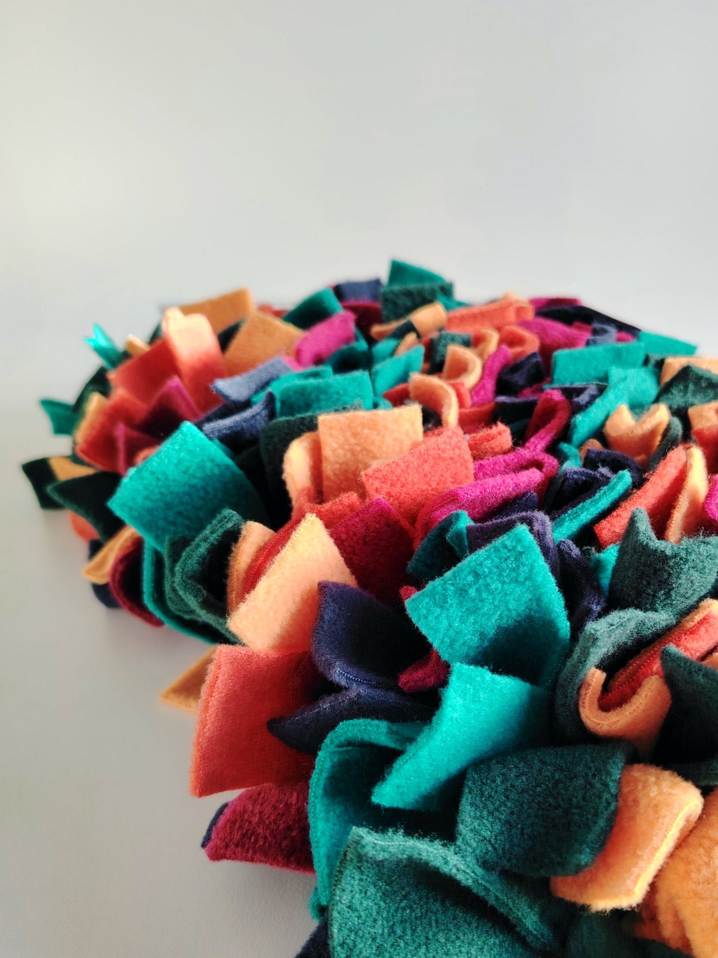 Close-up side view of warm-toned snuffle mat showing layered fleece texture.