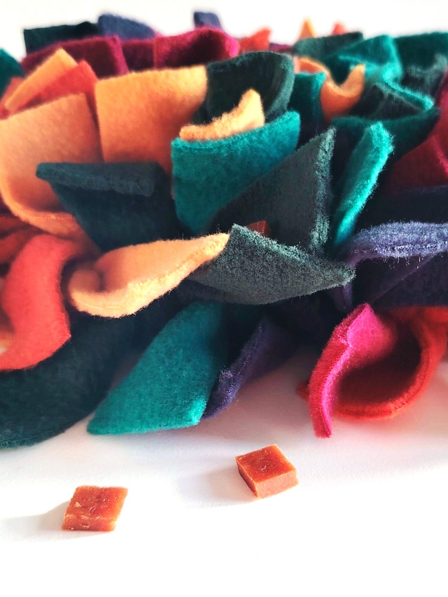 Dog treats hidden in warm-toned snuffle mat for foraging enrichment.