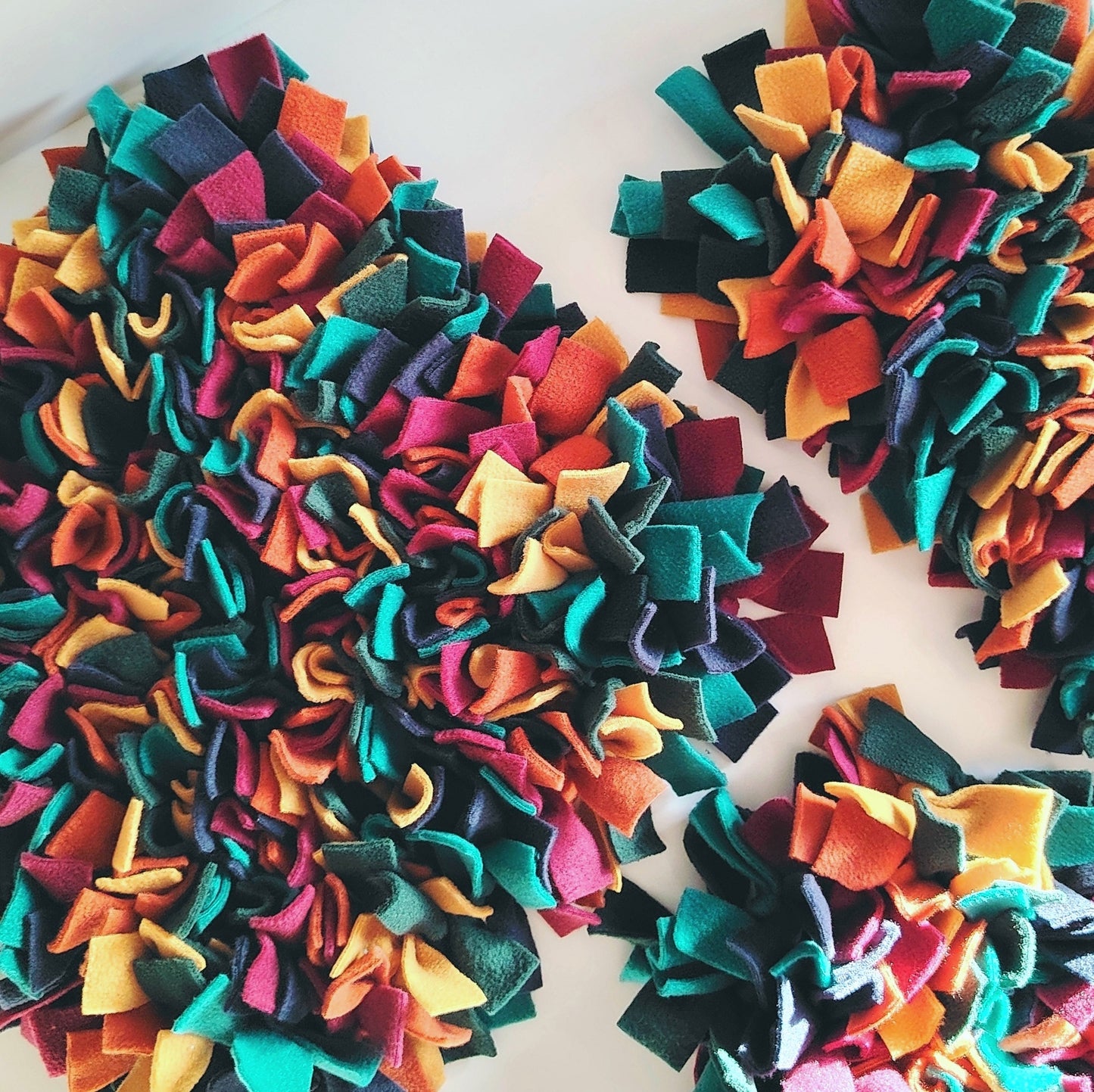Group of warm-toned snuffle mats showing colour variation and design.