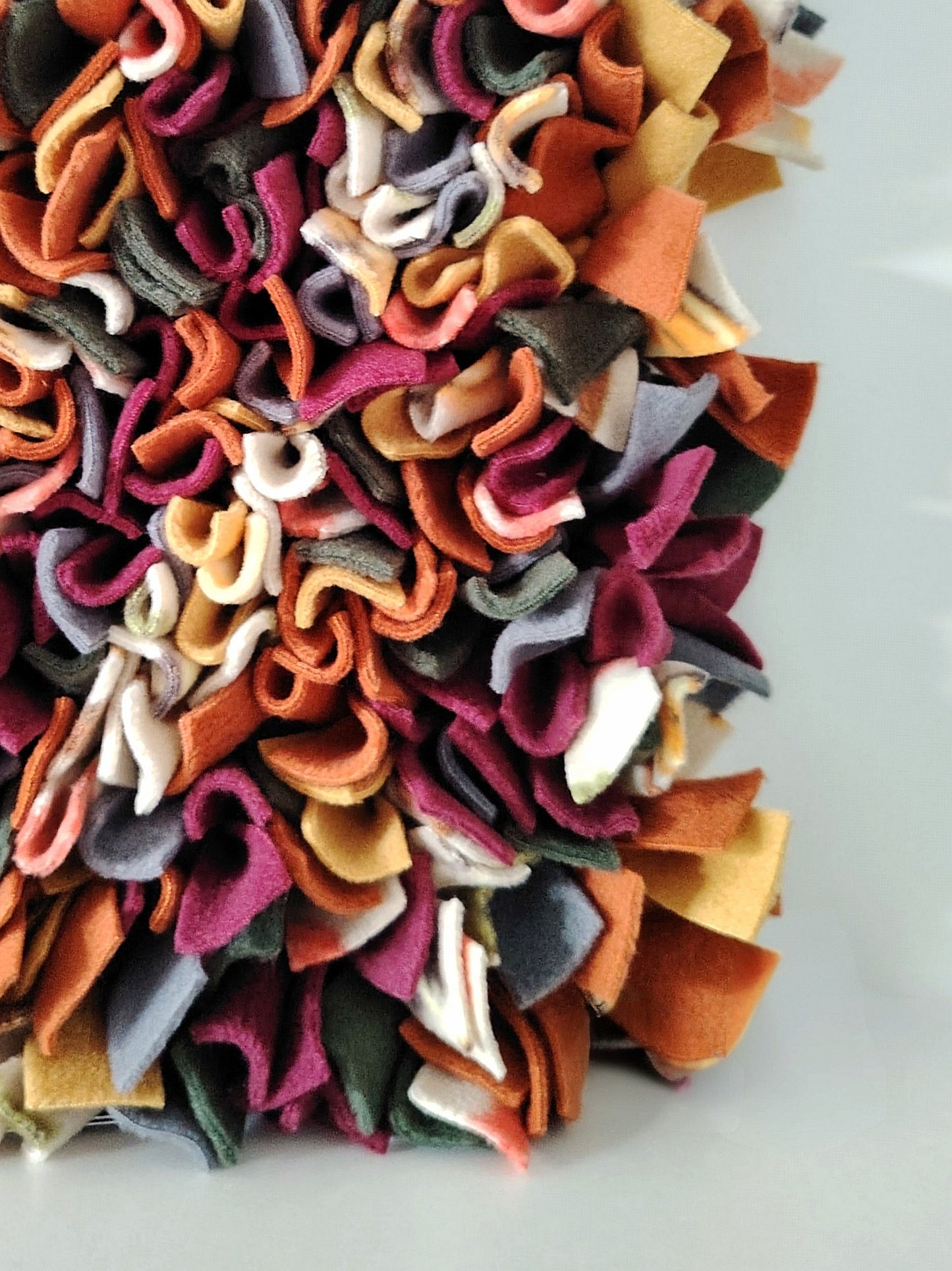 Close-up of a handcrafted Nova Zeal Autumn Snuffle Mat in rust, mustard, plum, charcoal and forest green fleece.
