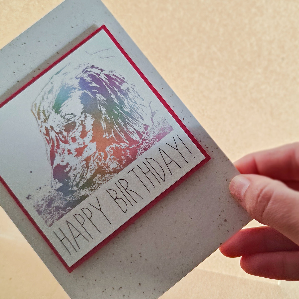 Close-up of a colourful Cocker Spaniel Happy Birthday card held in hand.