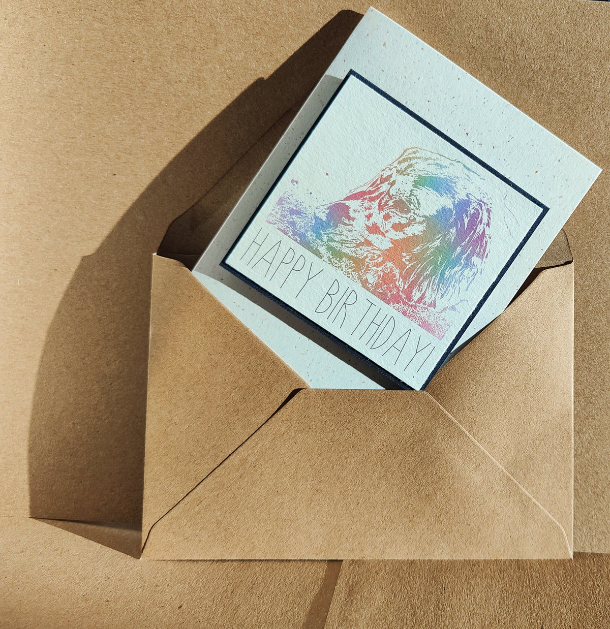 Cocker Spaniel birthday card shown inside a kraft envelope, featuring a colourful digitally illustrated spaniel design.