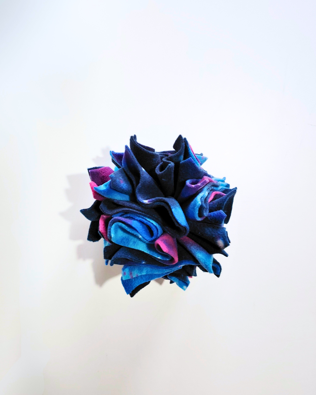 View from above looking down on a small pet enrichment toy on a white background