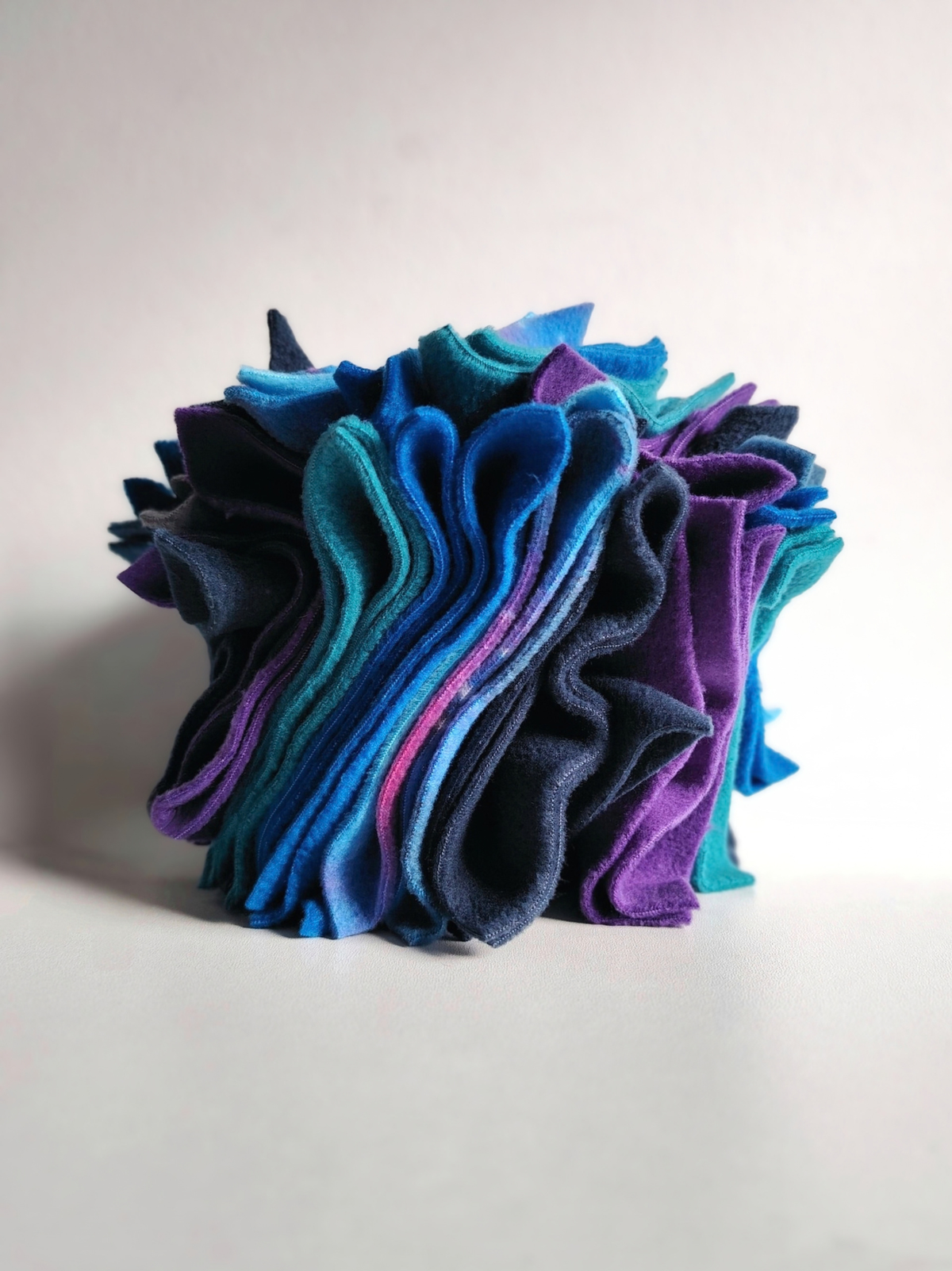 Large handmade Nova Zeal Night Sky Scruffle Ball featuring densely layered folds of navy, royal blue, teal and purple fleece, photographed against a light background.