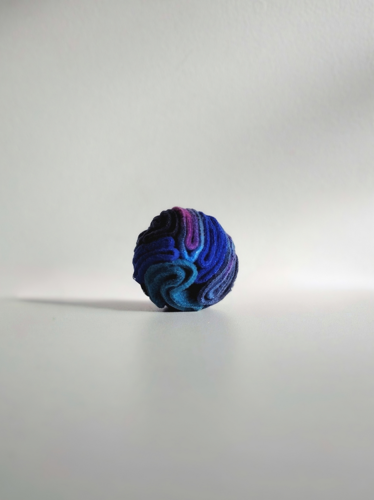 Nova Zeal Night Sky Pocket Snuffle Ball made from folded navy, royal blue, teal and purple fleece, standing upright against a white background.