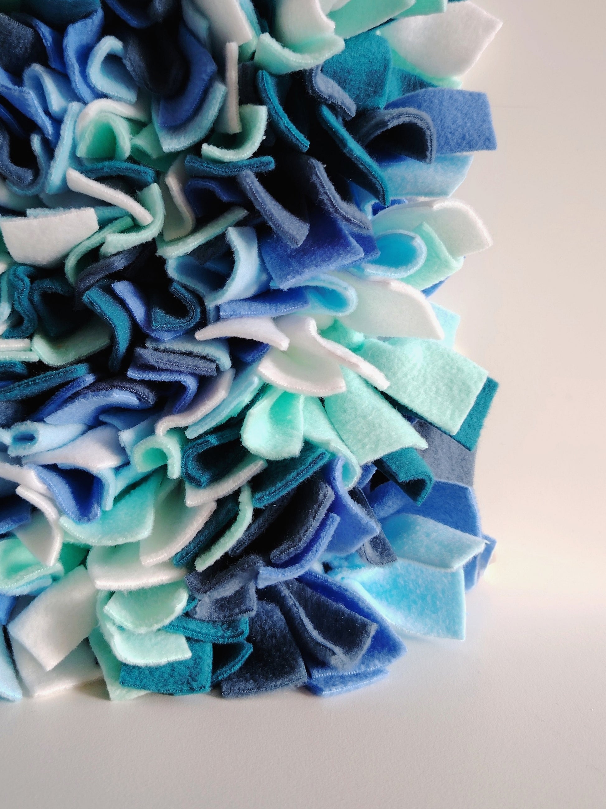 Close-up of blue and white fleece snuffle mat dog enrichment toy by Nova Zeal.
