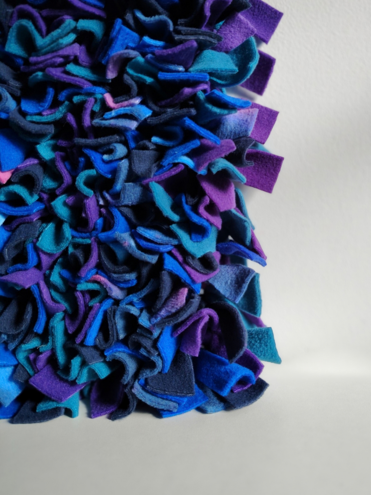 Close-up of a Nova Zeal Night Sky Snuffle Mat showing densely folded navy, royal blue, teal and purple fleece against a light background.