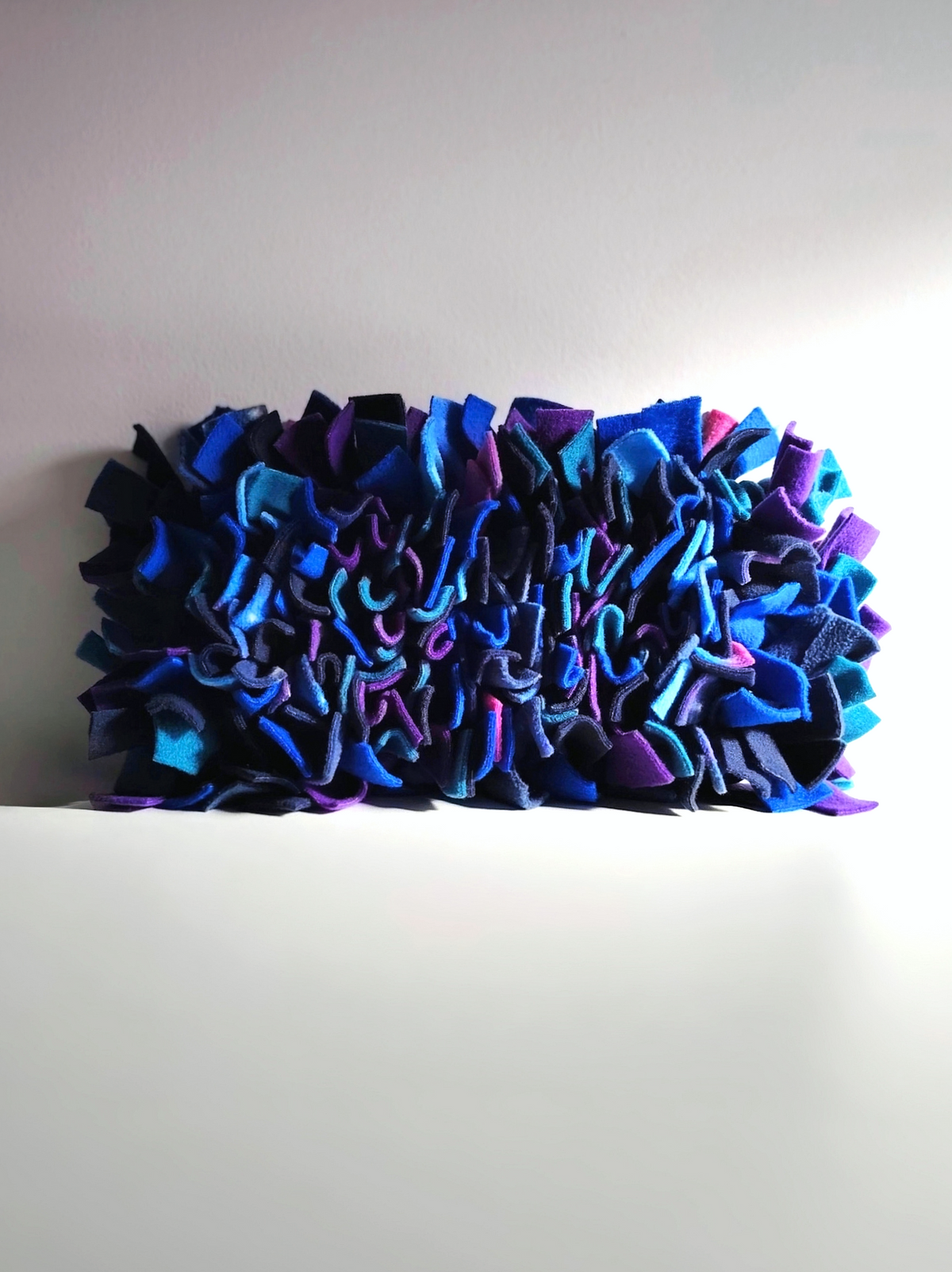 Side profile of Nova Zeal's Night Sky Snuffle Mat, showing the depth and density of its navy, royal blue, teal, purple and galaxy-patterned fleece strips.