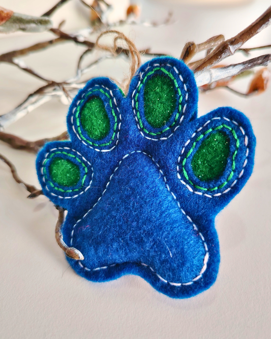 Blue paw print with green centers on a branch background