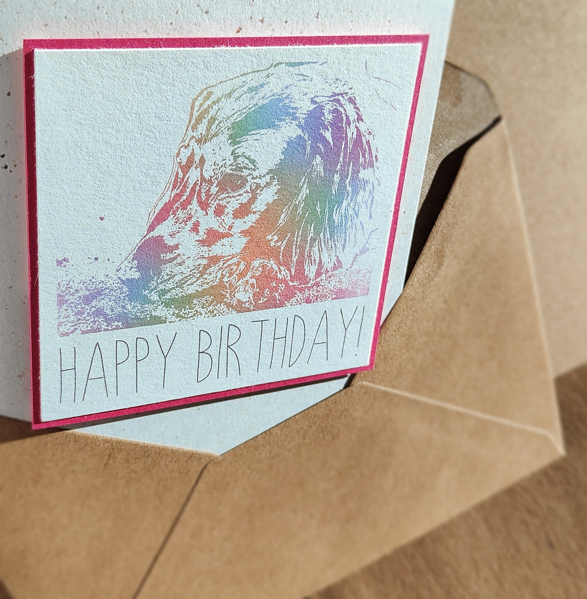 Pink Cocker Spaniel birthday card with colourful digitally illustrated spaniel design shown with a kraft envelope.