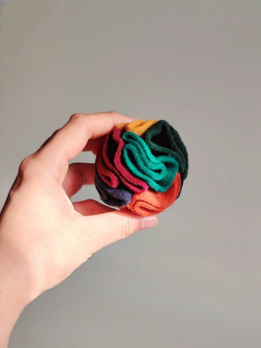 Warm pocket snuffle ball held in hand showing size for dog enrichment