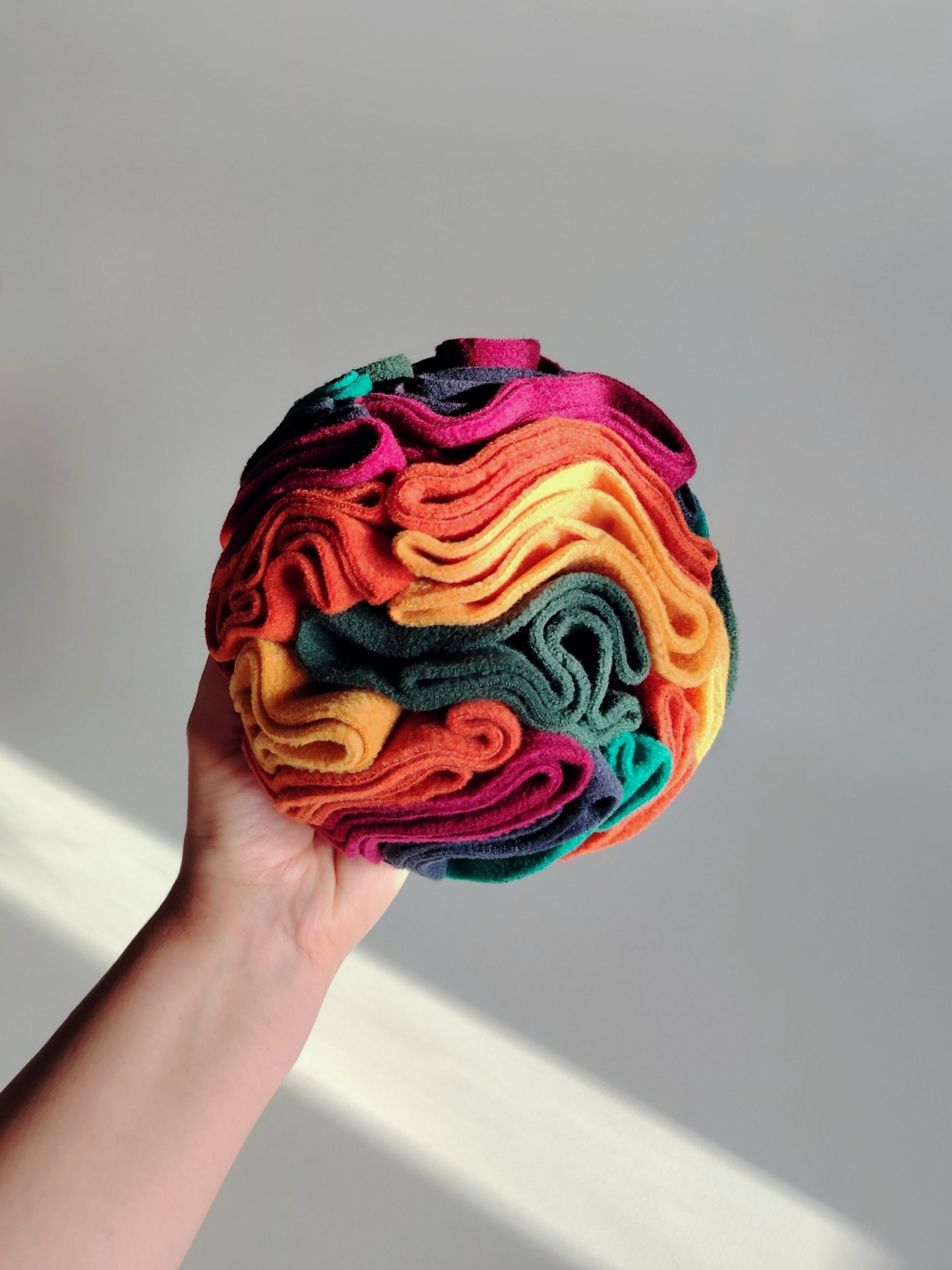 Warm colour snuffle ball close up showing fleece layers and texture.